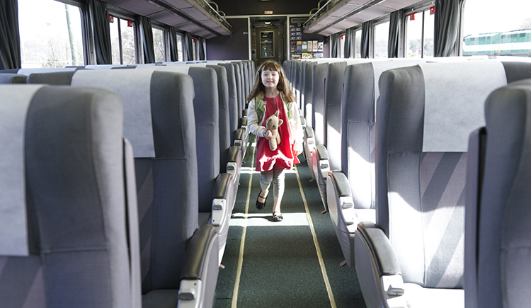 A child walks down the aisle of a train